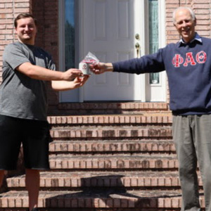History major Macon Bullock (left) receives a history department mug and Phi Alpha Theta honor cord from Dr. Stephen Carls during a special ceremony at Carls's home in May 2020.
