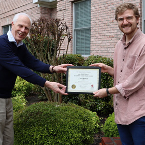 Graduating history major Luke Sower (right) accepts the Phi Alpha Theta Academic Excellence Award from Dr. Stephen Carls in May 2020. The award also consisted of a Phi Alpha Theta Scholarship Pin.