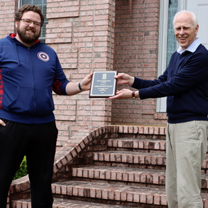 Graduating Phi Alpha Theta member and history major Christopher Hearn receives his History Major Award from Dr. Stephen Carls in May 2020.