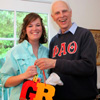 Sarah Carroll, a graduating Phi Alpha Theta member with a double major in history and political science, accepts a graduation award bag from Dr. Stephen Carls at the annual Phi Alpha Theta cookout on May 8, 2015.