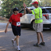 Dr. Alice-Catherine Carls, a competitor in the 5k race at the Racing So They Can Ride event on September 19, 2015, gets a high five from Phi Alpha Theta race volunteer Robert Briley.