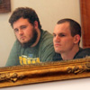 A mirror captures Nicholas Hancock (left) and Jonmark Hetrick engaged in conversation during the Phi Alpha Theta Best Chapter Award pizza party on October 16, 2015.