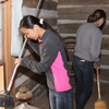 Katherine Cheshire (left) brushes cobwebs off a piece of furniture inside a cabin room at Britton Lane Battlefield on November 3, 2015. Sweeping the floor behind her is Beth Adams.