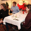 Attendees at the Phi Alpha Theta Franco-American Christmas dinner listen to Allen Bradley play a song on his shuttle pipes. They are (left to right) Beth Adams, Gideon Ragland, Emily Littleton, and Dr. Keith Bates.
