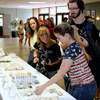 Students pick items to purchase at the Phi Alpha Theta bake sale on April 20, 2016. Hannah Conway (wearing red T-shirt) and Beth Adams (second from left) work as salespersons.
