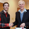 Phi Alpha Theta member Luke Adkins (left) receives congratulations from Dr. Stephen Carls at the history department's Christmas dinner on December 10, 2016, for his successful completion of a bachelor of science program in history at Union University.