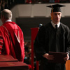 History major Luke Adkins heads back to his seat after receiving his bachelor of science diploma from Union University President Dr. Samuel W. "Dub" Oliver (back to camera) at the school's fall graduation on December 17, 2016. Photo by Kristi Woody