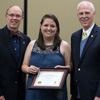 Emily Littleton accepts the Phi Alpha Theta Scholarship Pin and Academic Excellence Award from Robert Briley (left) and Dr. Stephen Carls at the history awards banquet on May 4, 2017. Photo by Janelle Vest