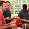 Attendees go through the food line at the 25th Annual Phi Alpha Theta/History Department Cookout at Dr. Carls's home on May 12, 2017. They are (front, left to right) Jeremy Ebert, Jeff Williams, Luke Parrett, and Stephen Lewoczko. In the background are Haelim Allen (center right) and Dr. Henry Allen (right, back to camera).