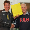Phi Alpha Theta member Stephen Lewoczko (left) and Dr. Stephen Carls share a lighthearted moment as Carls presents a graduation award bag to Lewoczko at the history department cookout on May 12, 2017.