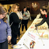 Lauren Butler (right) waits on students in the chapel foyer at the Phi Alpha Theta bake sale on April 11, 2018.