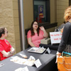 Lauren Butler (seated, left) and Jessica Barton (seated, center) talk to a customer at the Phi Alpha Theta bake sale near the Lexington Inn on April 11, 2018.
