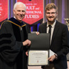 Phi Alpha Theta member Luke Sower (right) accepts the first place award from Dr. Stephen Carls in the Dr. James Alex Baggett History Research Paper Competition during Union University's Awards Day Convocation on May 4, 2018. Photo by Janelle Vest