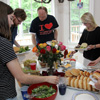 Attendees at the Phi Alpha Theta cookout go around the food table on May 12, 2018. They are (left to right, going clockwise) Brittany Staggs, Luke Sower, Robert Briley, Brenda Briley, Ali Renckens, and Joanna Butcher.