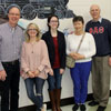 Representatives of Phi Alpha Theta at the pancake breakfast that the Jackson Old Hickory Rotary Club sponsored on March 16, 2019, stand in front of a wall painting of Casey Jones' locomotive at Andrew Jackson Elementary School, site of the Rotary fundraiser. They are (left to right) Robert Briley, Brenda Briley, Lauren Butler, Dr. Alice-Catherine Carls, and Dr. Stephen Carls.