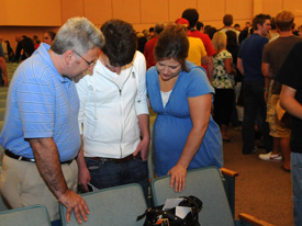 Tim and Marjorie Hester pray with their son T.J. Hester following the worship service for freshmen and their families. (Photo by Morris Abernathy)