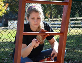 Union sophomore Sarah Bostic paints playground equipment at Pleasant Plains Baptist Church as part of last year's Campus and Community Day. (Photo by Jacob Moore)