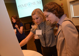 Biology major Erin Spencer discusses her research with biology professor Jennifer Gruenke during the Scholarship Symposium. (Photo by Morris Abernathy)