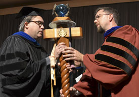 Justin Barnard (right), the 2013 winner of the Carla D. Sanderson Faculty of the Year Award, accepts the mace from last year's winner, Gavin Richardson. (Photo by Morris Abernathy)