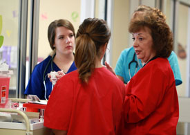 Mary Lee Jacobson, assistant professor of nursing, helps a group of nursing students prepare for a simulation. Union's online graduate nursing program recently earned high marks from U.S.News & World Report. (Photo by Kristi Woody)
