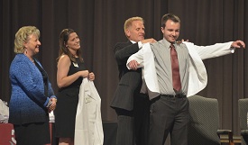 Fifty-six new pharmacy students received their white coats from Associate Dean George A. DeMaagd and Founding Dean Sheila Mitchell. (Photo by Morris Abernathy)