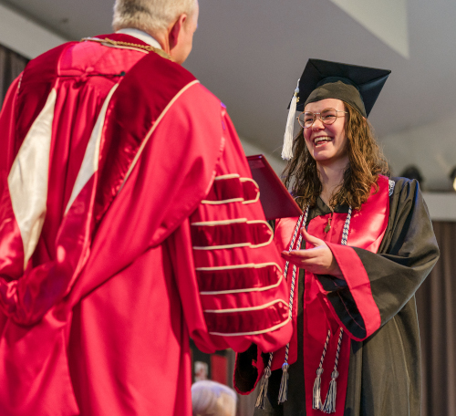 Michaela Napier of Hermitage, Tennessee, is presented with her degree and congratulated by Union University President Samuel W. "Dub" Oliver during commencement exercises Dec. 17. (Photo by Kristi Woody)