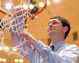 Lady Bulldogs coach Mark Campbell cuts down a piece of the net at Oman Arena after winning the 2009 NAIA championship. (Photo by Kristi McMurry)