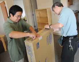 Computer science professor Max Haifei Li and physics professor David Ward help unpack and assemble furniture in Union's new student housing complex. (Photo by Morris Abernathy)