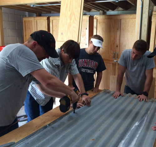 Union engineering professors (from left) Randy Schwindt and Georg Pingen and senior engineering students  Erin Picard and Chris Boccarossa build a rough design of a solar water heater at an orphanage in Honduras.