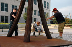 Union University art students, Rob Alsobrook (left) and Nathan Evans (right), assist artist STRETCH with leveling his sculpture, "Guardian."