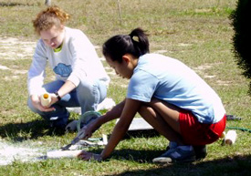 Union students Amy Ashburn (left) and Eunice Sung clean paint brushes as part of their work in Gulfport, Miss.