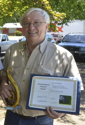 James Huggins, university professor of biology, displays his Environmental Stewardship Award. (Photo by Morris Abernathy)