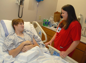 Matt Kelley, one of two Union University students who remains hospitalized after the Feb. 5 tornado, enjoys a light moment with nurse Alecia Hale at the Jackson-Madison County Hospital. (Photo by Morris Abernathy)