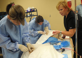 Molly Wright (right) works with nurse anesthesia students on simulations in Providence Hall. (Photo by Morris Abernathy)