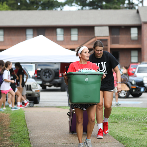 Karen Sinclair, assistant professor of athletic training education, and Christa Karns, senior social work major, help new students move in during Welcome Week Aug. 17. (Photo by Kristi Woody)