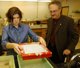 Senior Melanie Rickett takes the tray of paper pulp to the next step of the paper making process, as chemistry professor Jimmy Davis supervises. (Photo by Morris Abernathy)