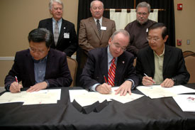 Front row, from left, Choon Sam Fong, David S. Dockery and Peter Tang sign the three-year partnership agreement between Union University and Baptists in Singapore. Union trustees (back row, from left) Lynn Edmonson, Fred Ward and Paul Priddy were also on hand for the Nov. 18 announcement of the partnership. (Photo by Beth Spain)