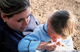 Union freshman Amelia Lewis watches as a Romanian girl colors a picture.