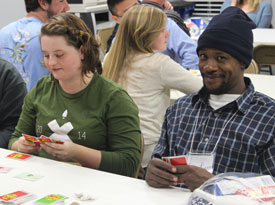Union student Elizabeth Neal (left) plays a game of Apples to Apples with a group of homeless men that Union students hosted for the night Nov. 18. (Photo by Emily Littleton)