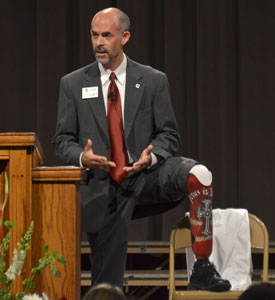 Kent Stoneking, chairman of pharmacy practice in Union's School of Pharmacy, reveals his prosthetic leg during an address to first-year pharmacy students Aug. 22. (Photo by Morris Abernathy)