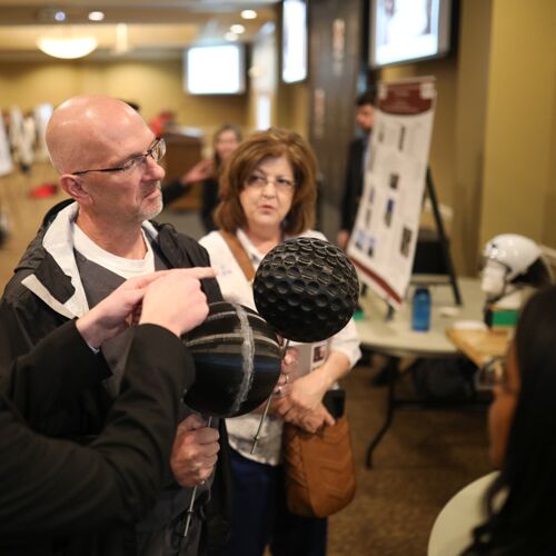 Paul Mayer, director for health services, examines aerodynamic spheres at the 2018 Scholarship Symposium. (Photo by Kristi Woody)