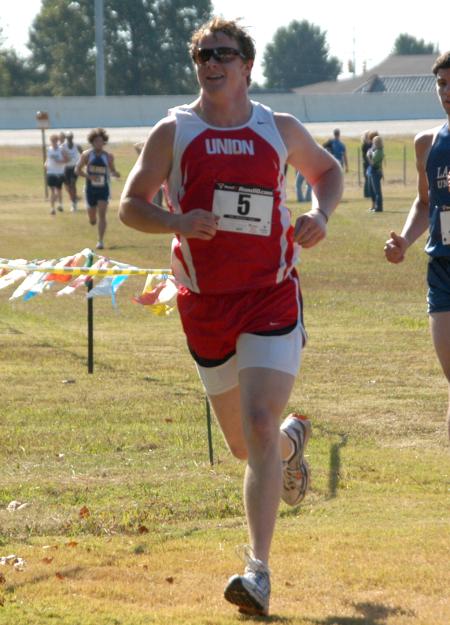 Grant Luke acknowledges some fans as he competes in the Union University Cross Country Invitational. - Photo by Steven Aldridge