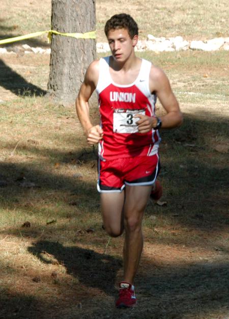 Joel Wellum races through a shady spot on the course during the Union University Cross Country Invitational. - Photo by Steven Aldridge