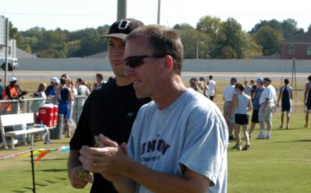 Union head cross country head coach Gary Johnson applauds the efforts of his runners, while Union baseball graduate assistant Greg Abram (back) watches. - Photo by Steven Aldridge