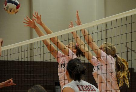 Lady Bulldogs Ashley Young (left) and Amanda Coyle (right) block a hit by Rhodes (Tenn.) College. - Photo by Morris Abernathy