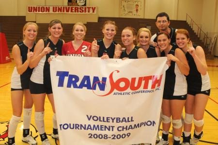 The Union Volleyball team surrounds their championship banner for a picture after winning the TranSouth Conference Tournament. - Photo by Morris Abernathy