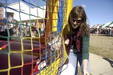 Senior education major Sarah Johnson helps Victor Meredith, grandson of Union employee Cindy Meredith, into the jumper during Arts in the Park. - Photo by Beth Spain