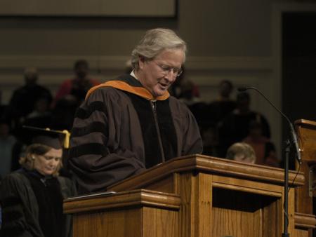 Jim Veneman, assistant professor of communication
arts, delivers a prayer at the fall graduation ceremony. - Photo by Jordan Buie