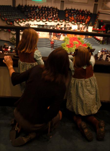 Emmi and Addi watch with their mother, Kelly Whittemore, for their father, Lail Whittemore, MBA graduate, to walk across the stage at the fall commencement service. - Photo by Angela Abbamonte