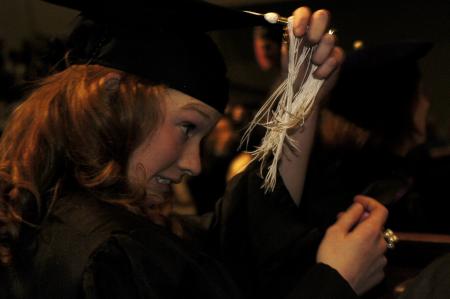 Lily Zopfi, art major, struggles to correct her tassel during the fall graduation ceremony.  - Photo by Beth Spain